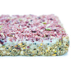 Close-up of a layered suet berry block with pink top and white bottom on a white background