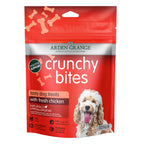 A red stand-up pouch of Arden Grange Crunchy Bites dog treats with a photo of a fluffy light-colored dog on the front. The package highlights 'tasty dog treats with fresh chicken' and shows product details like 'Naturally Hypoallergenic' and 'Digestive Support'.