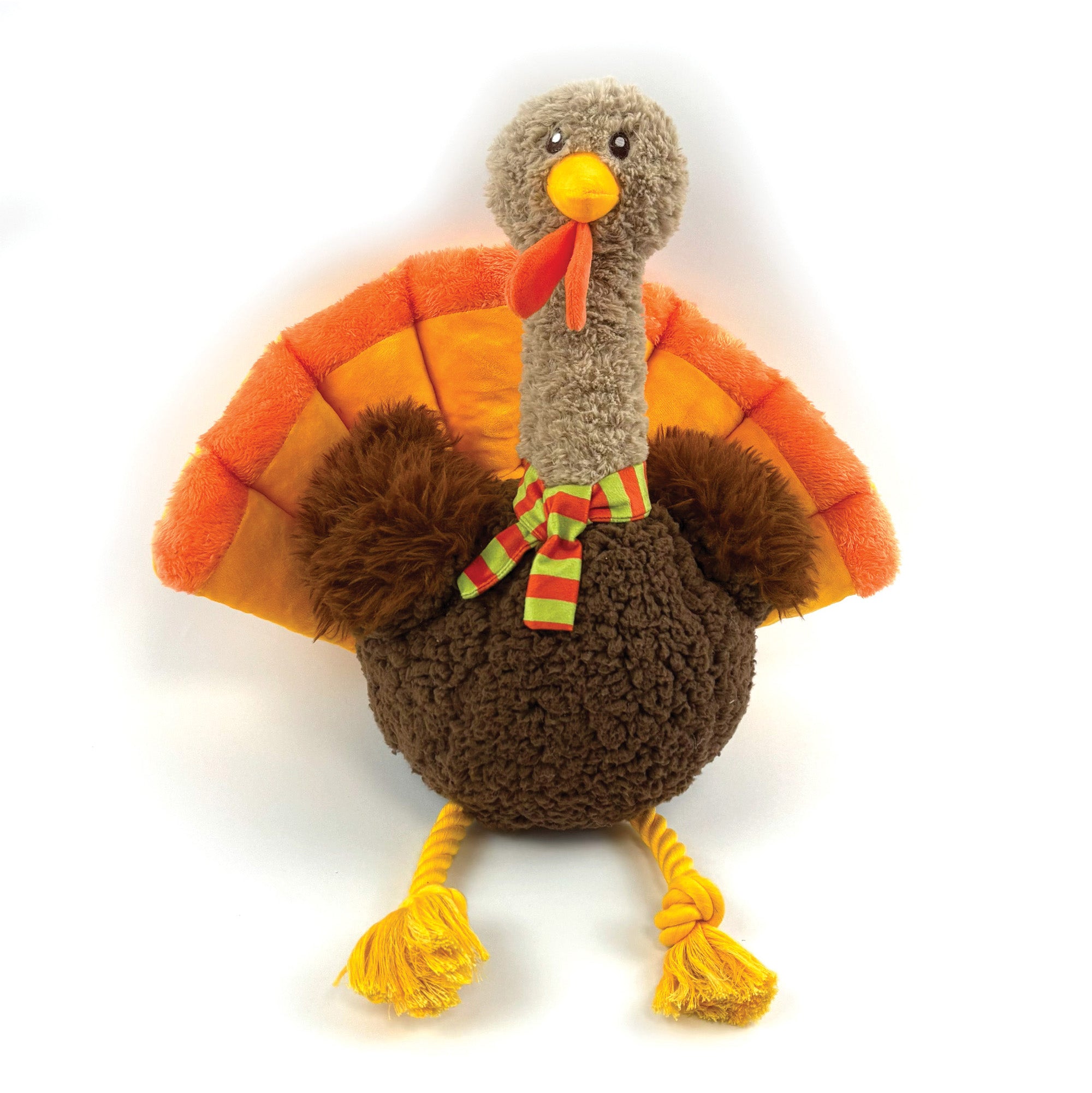 A plush turkey toy with a brown textured body, orange and yellow fan-shaped wings, a gray neck, yellow beak and legs, and a red wattle with a green and red striped bow, photographed on a white background.